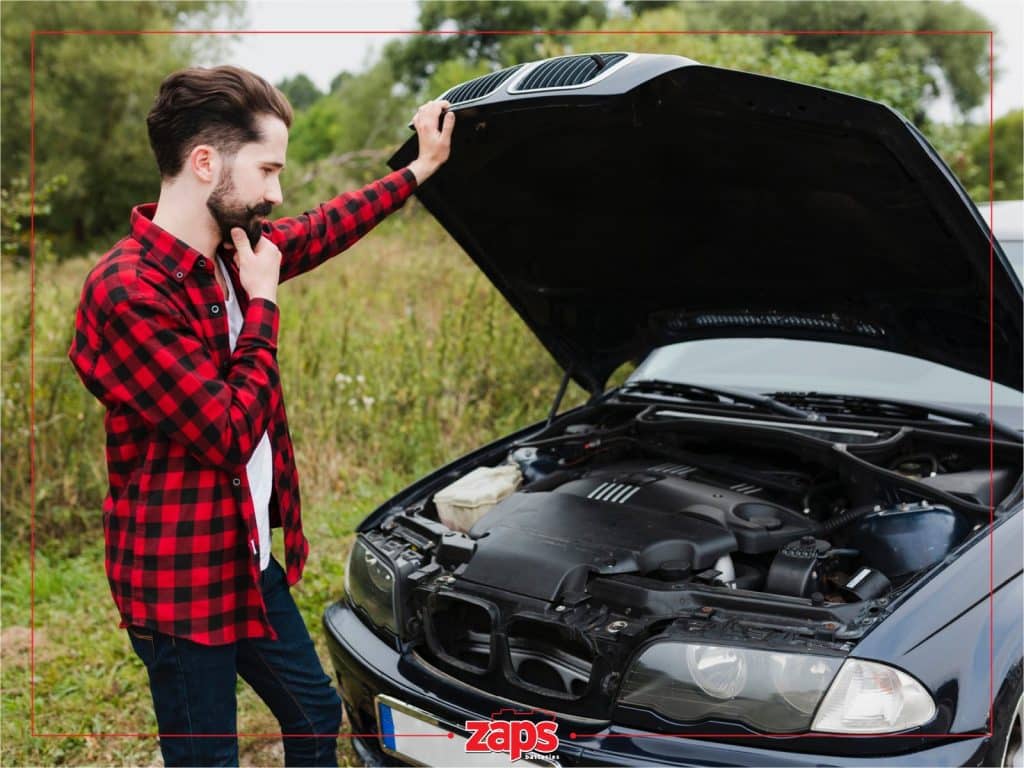 άνδρας έχει ανοίξει το καπό και κοιτάει την μπαταρία του αυτοκινήτου. Σκέφτεται πώς να κάνει έξυπνη επιλογή για μπαταρία αυτοκινήτου