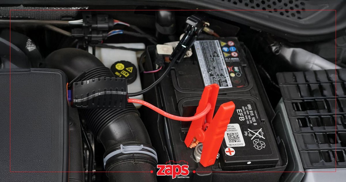 Εκκίνηση μπαταρίας αυτοκινήτου με booster, με κόκκινο καλώδιο και ακροδέκτες συνδεδεμένους.